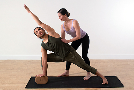 Gina assisting in a yoga posture